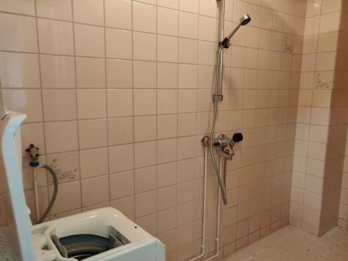 uma casa de banho com um chuveiro e um WC. em Yyterin valkoinen huoneisto 14A talo B 21 em Pori