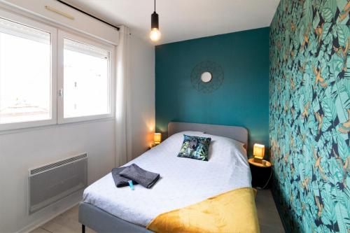 une chambre avec un lit avec un mur bleu dans l'établissement JANA HOUSE - HYPERCENTRE - GARE - NETFLIX, à Toulouse