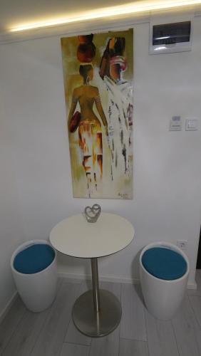 a table and two chairs in a room with a painting at Anna Villa Füred Boutique Rooms in Balatonfüred
