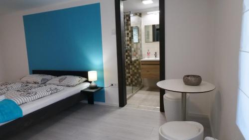a bedroom with a bed and a table and a bathroom at Anna Villa Füred Boutique Rooms in Balatonfüred