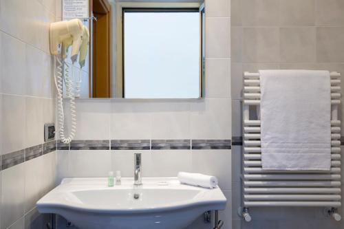 a bathroom with a sink and a mirror and a window at Park Hotel in Mondovì