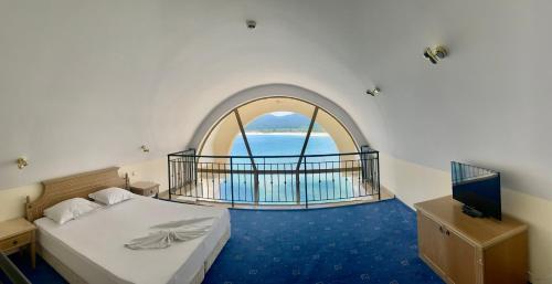 a bedroom with a bed and a large window at Duni Marina Royal Palace Hotel - Ultra All Inclusive in Sozopol
