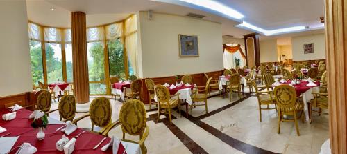 een restaurant met tafels en stoelen met rode tafelkleden bij Duni Marina Royal Palace Hotel - Ultra All Inclusive in Sozopol