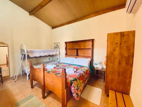 1 dormitorio con 1 cama con cabecero de madera en Le Ginestre Alghero, en Olmedo
