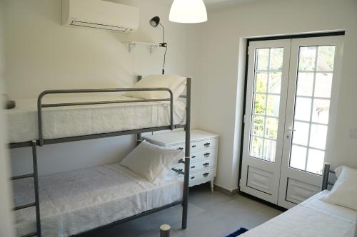a bedroom with two bunk beds and a window at Casa Do Tio Arménio in Ponte de Lima