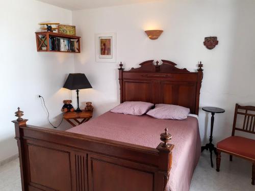 una camera con un grande letto in legno e una sedia di VV - Casa Para Ti a La Asomada