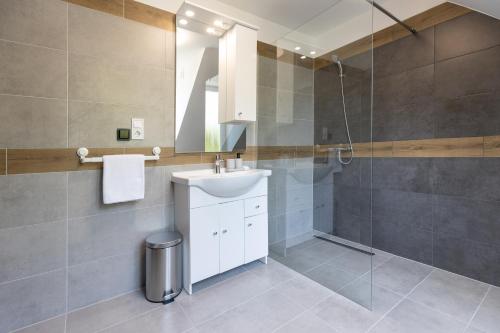 a bathroom with a sink and a shower at Panzió 81 in Hajdúszoboszló