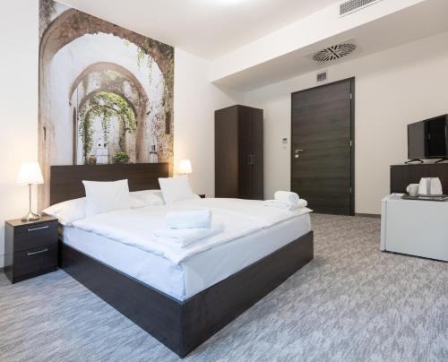 a large bedroom with a large bed and a television at Panzió 81 in Hajdúszoboszló