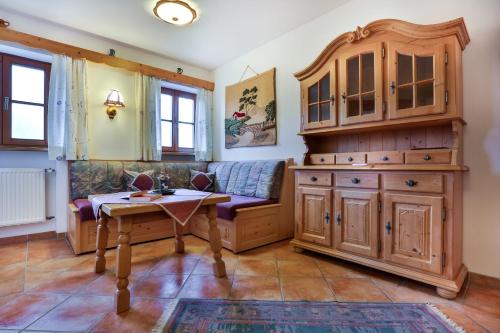 una sala de estar con un armario de madera y una mesa. en Haus Unterwegscheid Ferienwohnungen, en Ramsau