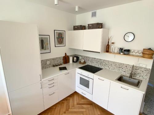 a white kitchen with white cabinets and a sink at Apartament Jan III Sobieski in Rzeszów