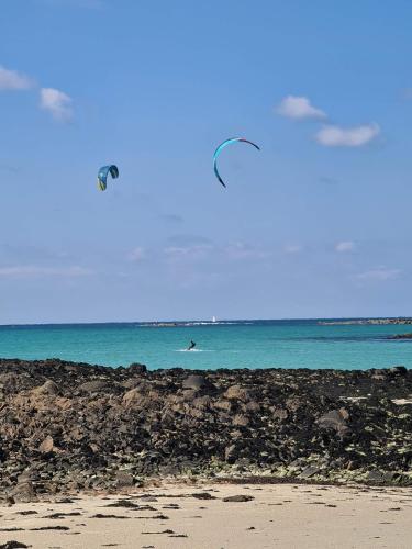 a person on the beach flying a kite at Dépendance Spacieuse & Cosy Entre et Mer avec Spa in Landéda