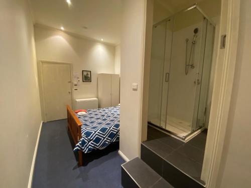 a small bathroom with a bed and a shower at Malvern Backpackers in Melbourne