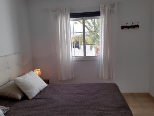 a bedroom with a bed and a window at Casa Para Ti Delfinesse in Puerto del Carmen