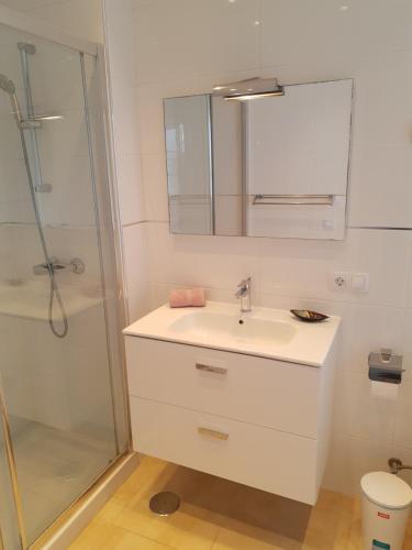 un bagno bianco con lavandino e doccia di Casa Para Ti Delfinesse a Puerto del Carmen