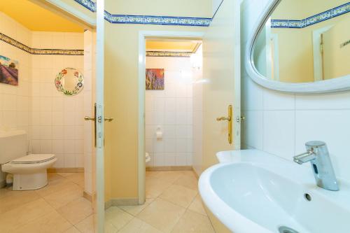 Un baño con lavabo, inodoro y espejo. en La Hacienda, en Vilvoorde