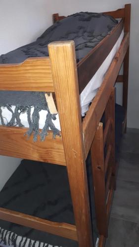- un lit superposé en bois avec une couette noire dans l'établissement Studio cabine avec jardinet à 30 m de la plage, au calme., à Gruissan
