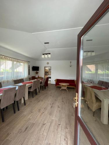 a dining room with tables and chairs and a sliding glass door at Evelyn Panzio in Corund