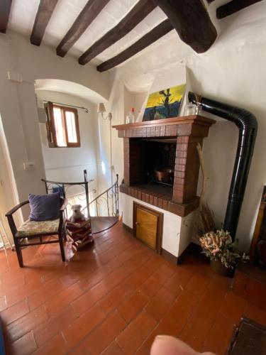a living room with a fireplace and a chair at La casetta del frontone in Cetona