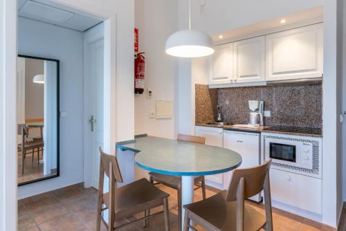 a kitchen with a table and chairs in a room at Calallonga Hotel Menorca in Mahón
