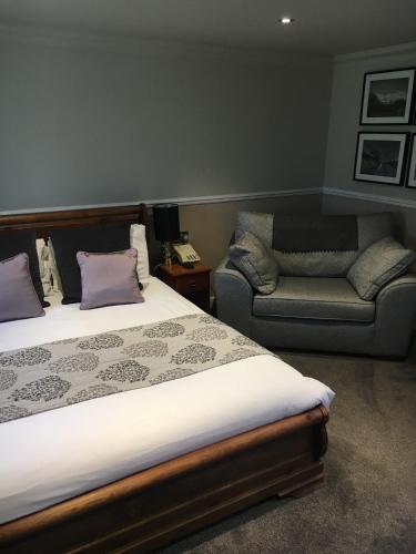 a bedroom with a bed and a couch and a chair at The Peel Aldergate in Tamworth