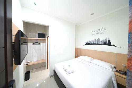 a hotel room with a bed and a bath tub at Heritel Urban Hostel in Jakarta