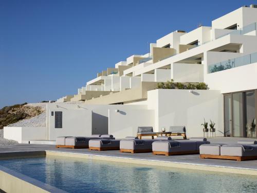eine Villa mit einem Pool vor einem Gebäude in der Unterkunft Domes White Coast Milos, Adults Only - Small Luxury Hotels of the World in Mytakas