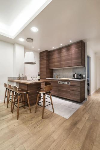 une cuisine avec des armoires en bois et une table et des chaises dans l'établissement 3 double bedrooms apartment in Montmartre near subway AC, à Paris