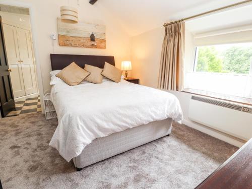 a bedroom with a large bed and a window at Pen-y-Craig in Rhyl