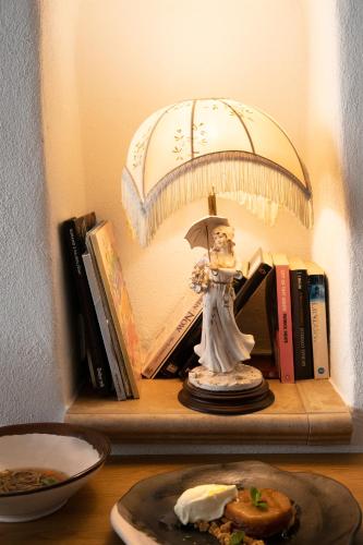 a shelf with a statue of a woman holding an umbrella at Hiša Linhart, Hotel & Restaurant in Radovljica