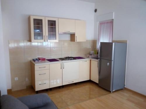 eine Küche mit einem Kühlschrank aus Edelstahl und weißen Schränken in der Unterkunft Apartment Bambino in Kaštela