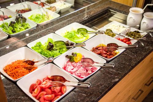 a buffet with several trays of different types of food at Wohlfühlhotel Berg Heil in Holzgau