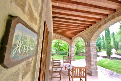 a patio with chairs and tables and a stone building at Fattorie di Celli in Poppi