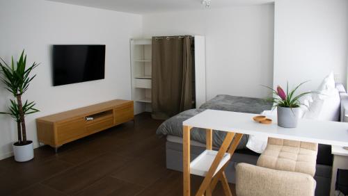 a room with a bed and a table and a tv at unique flat in Düsseldorf