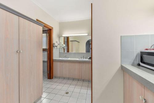 a kitchen with a sink and a refrigerator at Comfort Inn The Lakes in Mount Gambier