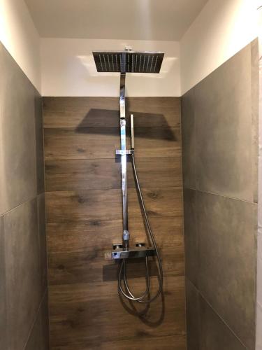 een douche in de hoek van een badkamer met houten vloeren bij Willa Mała Czarna in Wisła