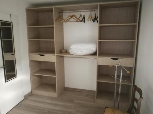 a walk in closet with wooden shelves at Appartement sympa T2 in Alès