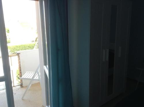 a window with a blue curtain next to a door at Il Pescatore in Marina di Pisa