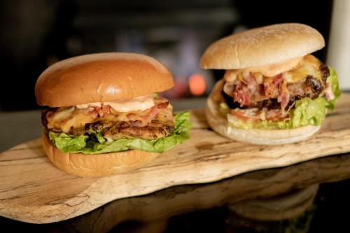 two sandwiches sitting on a wooden cutting board at Whitford House Hotel in Wexford