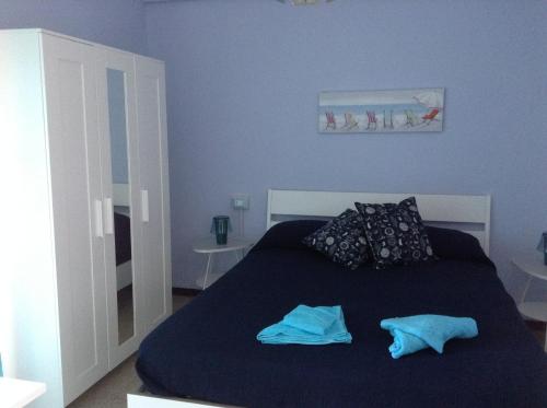 a blue bedroom with a bed with two pillows at Il Pescatore in Marina di Pisa