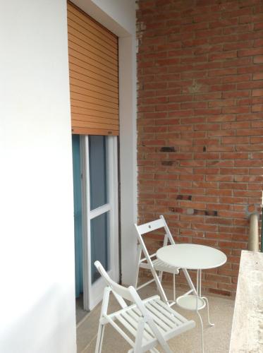 a table and two chairs sitting next to a brick wall at Il Pescatore in Marina di Pisa