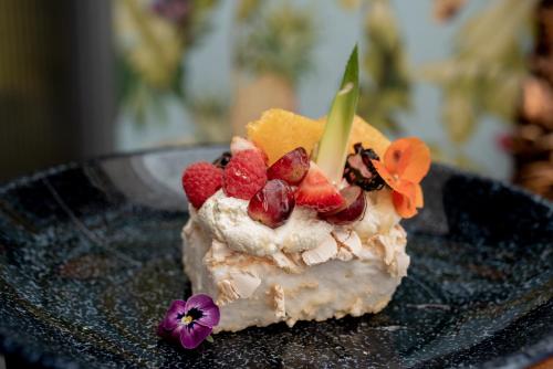 a piece of cake with fruit on a black plate at Whitford House Hotel in Wexford