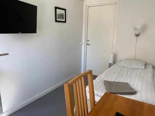 a bedroom with a bed and a table and a television at Gefle vandrarhem in Gävle