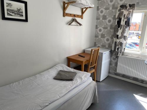 a bedroom with a bed and a table and a window at Gefle vandrarhem in Gävle