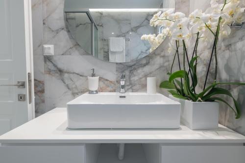 bagno con lavandino bianco e specchio di Narya Luxury Apartment a Ágios Rókkos