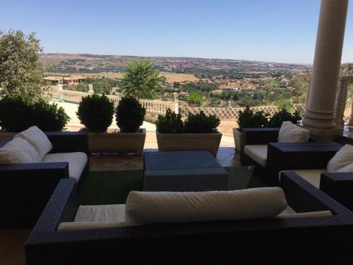 a patio with blue and white couches and plants at La Casa del Tejado Verde Toledo in Toledo