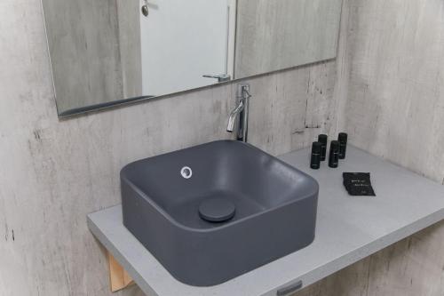 a blue sink in a bathroom with a mirror at Golden Star Praxitelous in Agia Marina Aegina