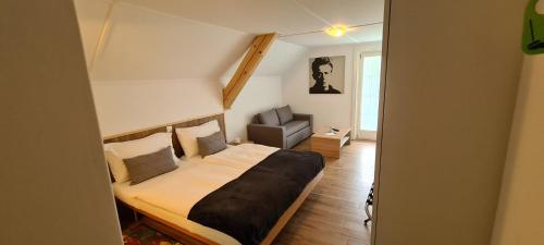 ein Schlafzimmer mit einem Bett und einem Stuhl darin in der Unterkunft Hôtel Restaurant Cave Bel-Air in Praz