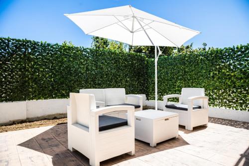 two white chairs and an umbrella on a patio at Ninfa Marina in Termoli