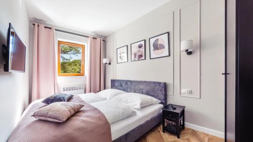 um quarto com uma cama com uma almofada em Sun & Snow prywatne apartamenty w obiekcie Nautikka Park em Krynica Morska