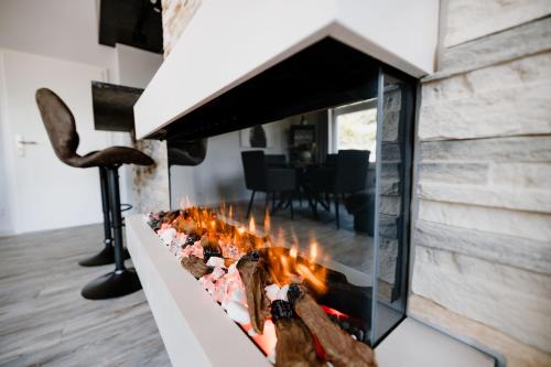 a fireplace in a living room with a stone wall at Ferienwohnung Waldgasthaus Armeleuteberg in Wernigerode